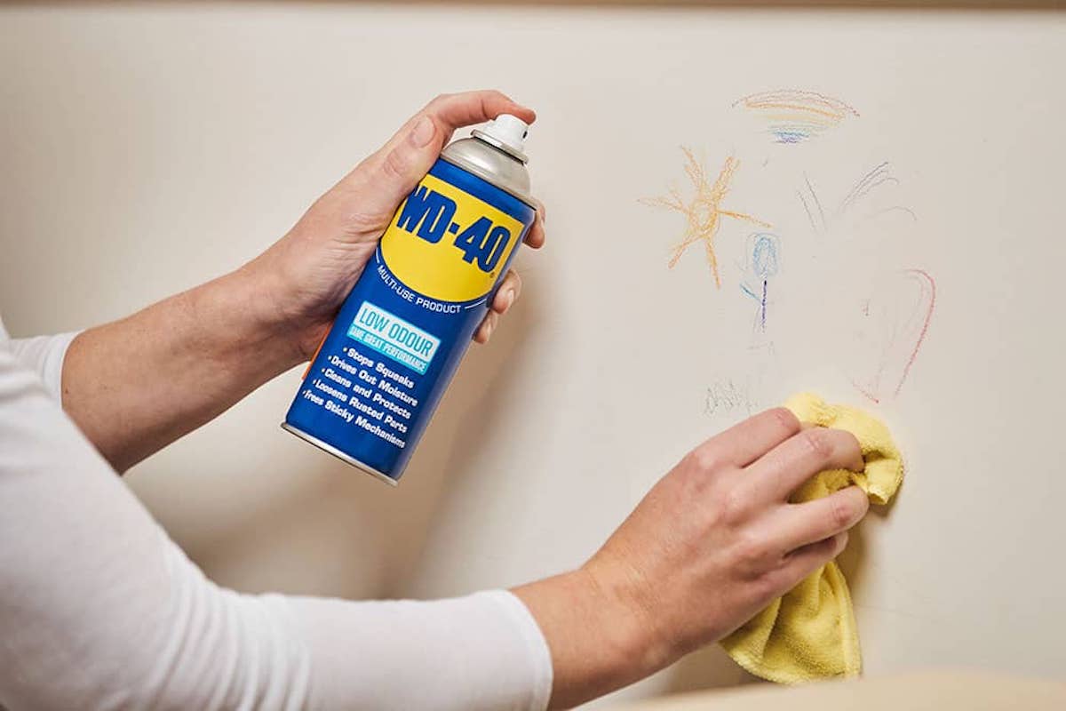 someone cleaning crayon marks from a wall with wd-40