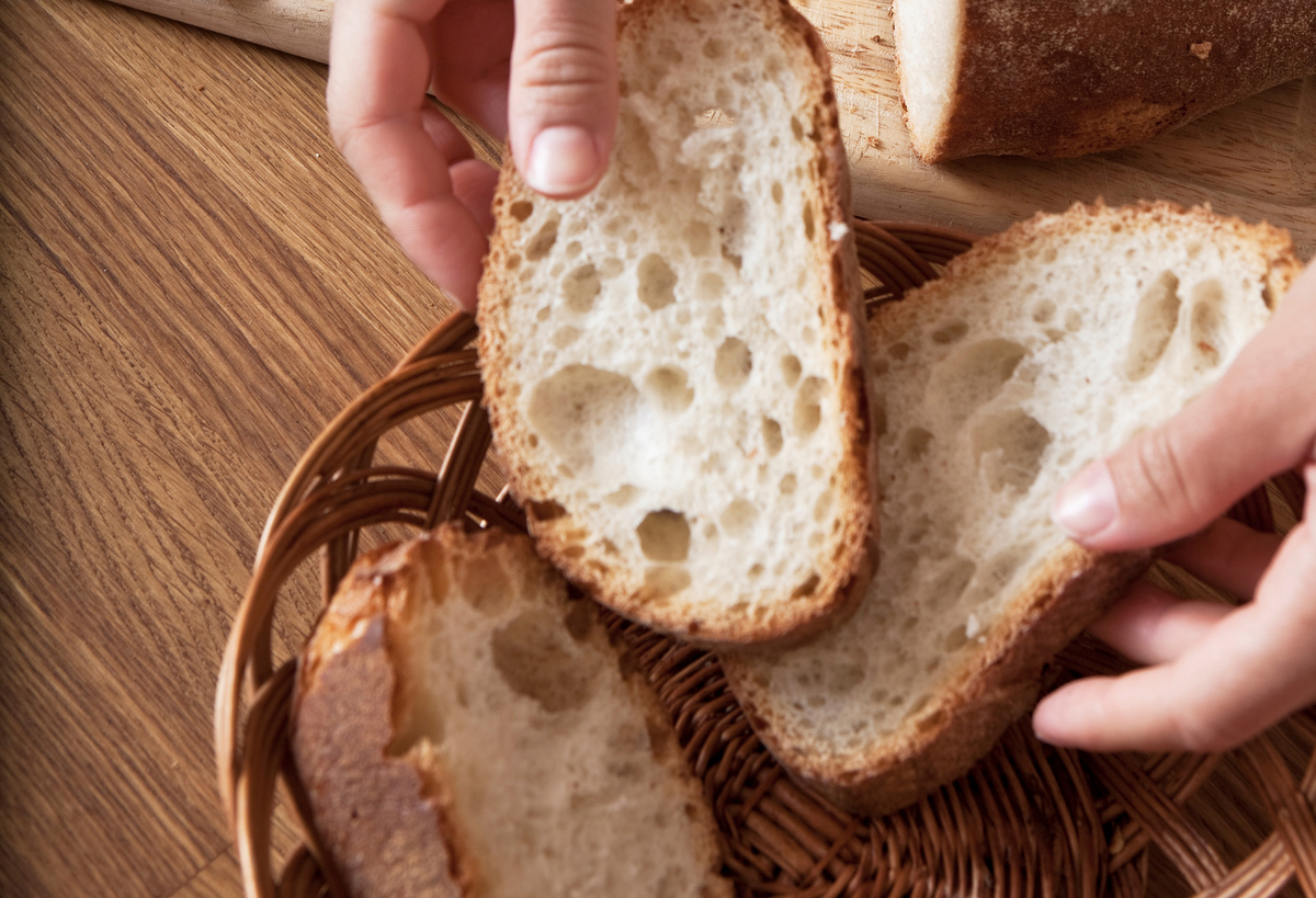 A woman sorts through slices of white bread.