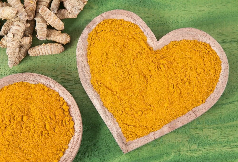 Powdered turmeric in a heart-shaped bowl