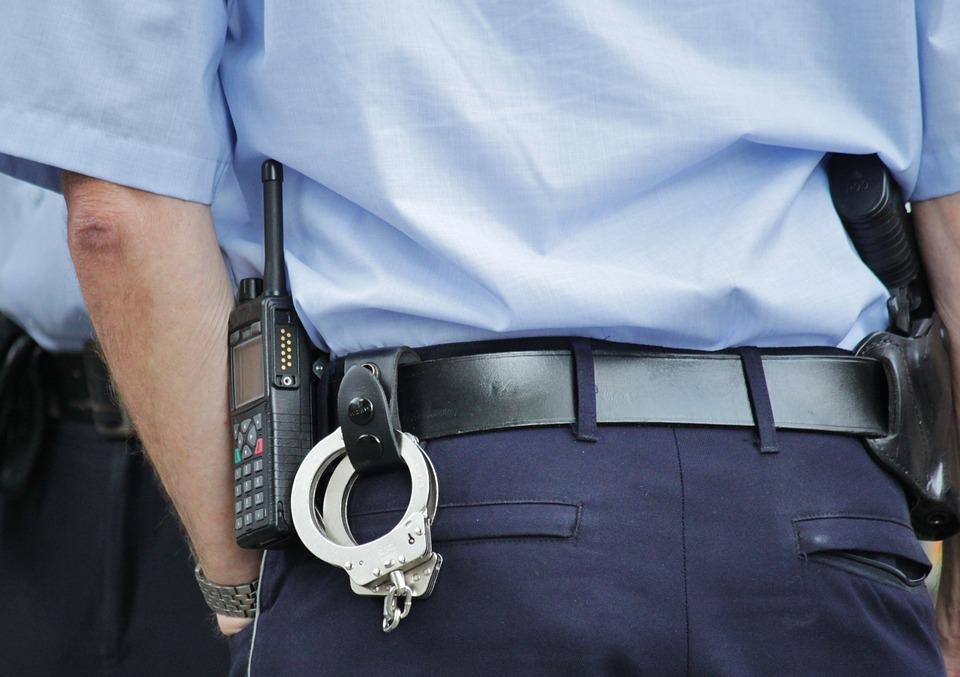 Hombre de seguridad con esposas, arma y radial